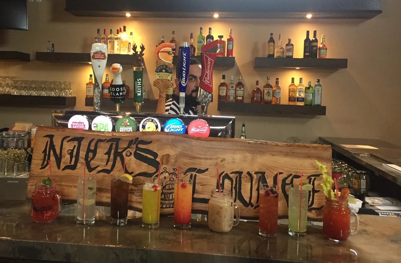 Cocktails lined up under the Nick's Lounge sign at the bar in Bonnyville, AB